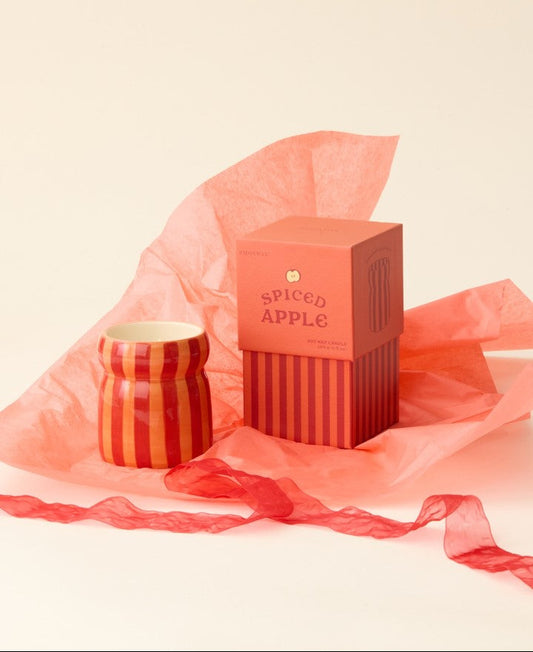 Candle and packaging with 'Spiced Apple' text on a beige background