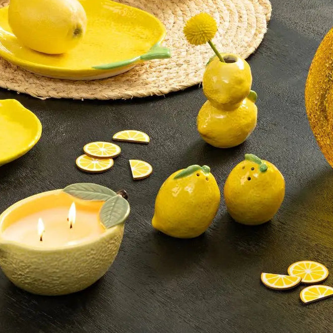 Yellow ceramic tea set with lemons on a dark surface